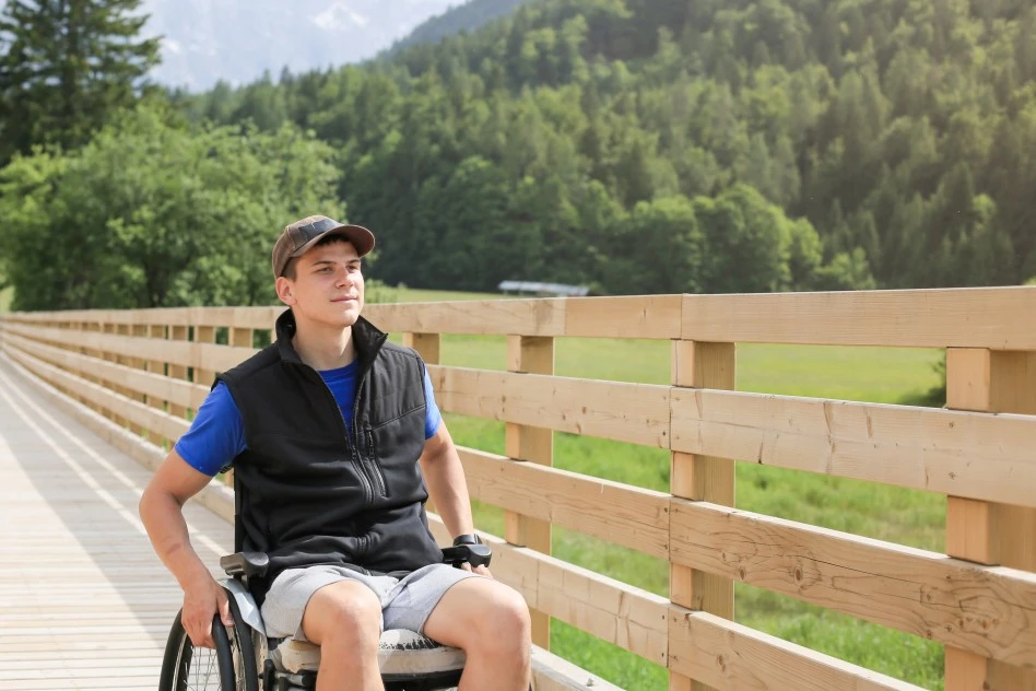 A disabled man sitting in his wheelchair enjoying outdoors