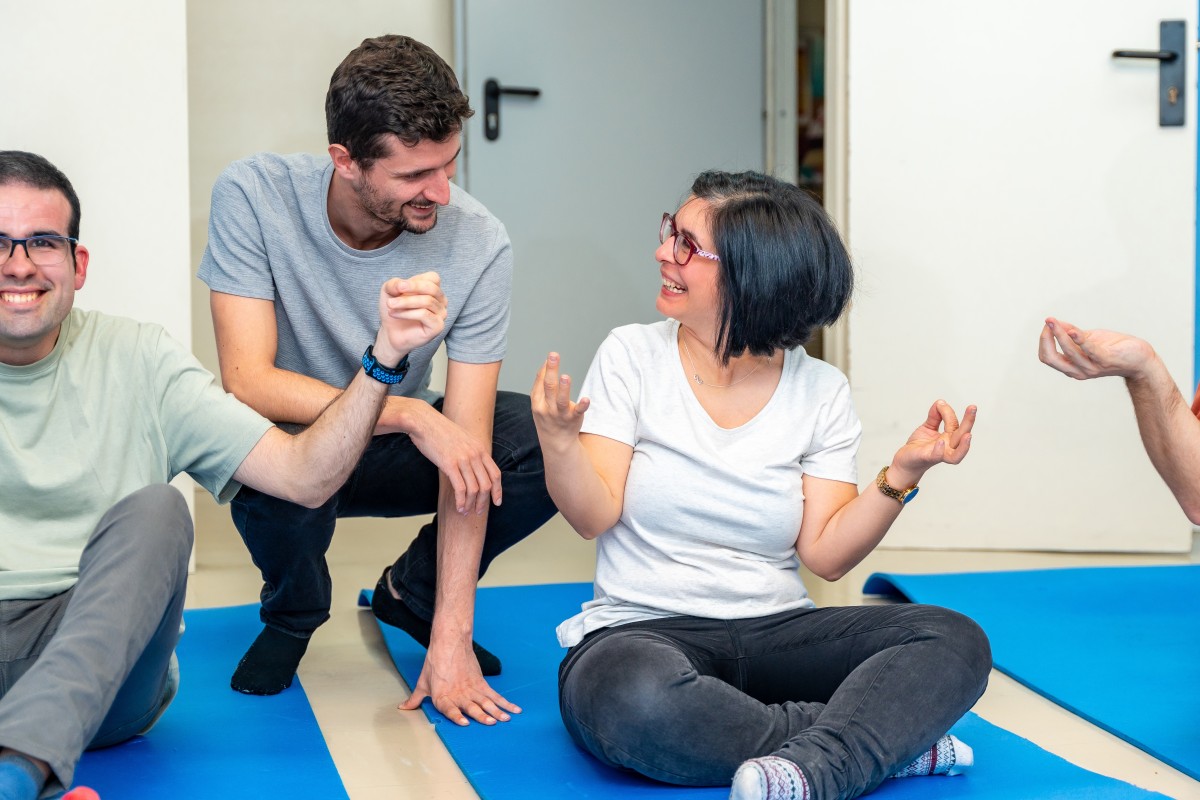 Disabled woman and her trainer helping her do yoga